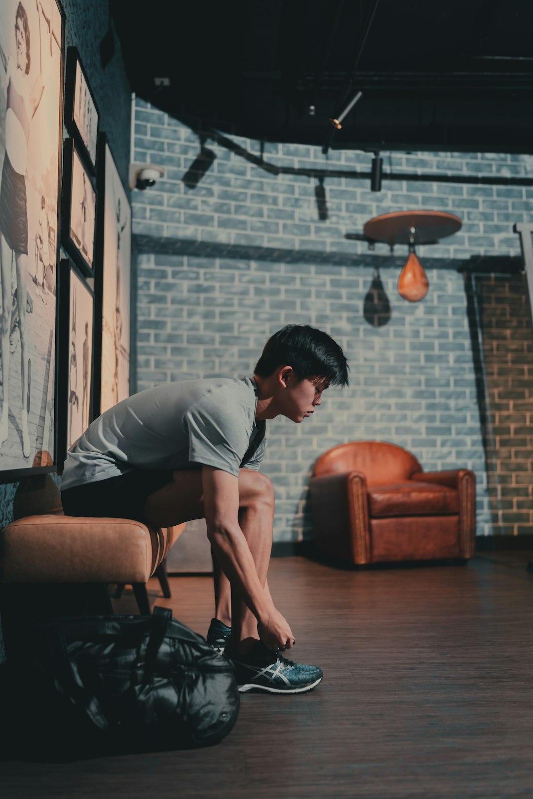 man in gray t-shirt sitting on brown leather armchair