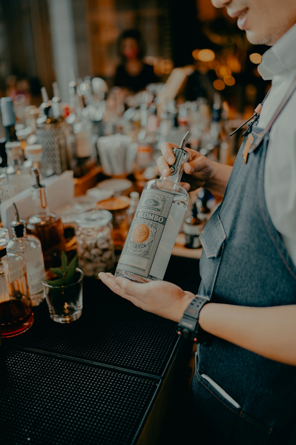 woman in gray shirt holding white labeled bottle