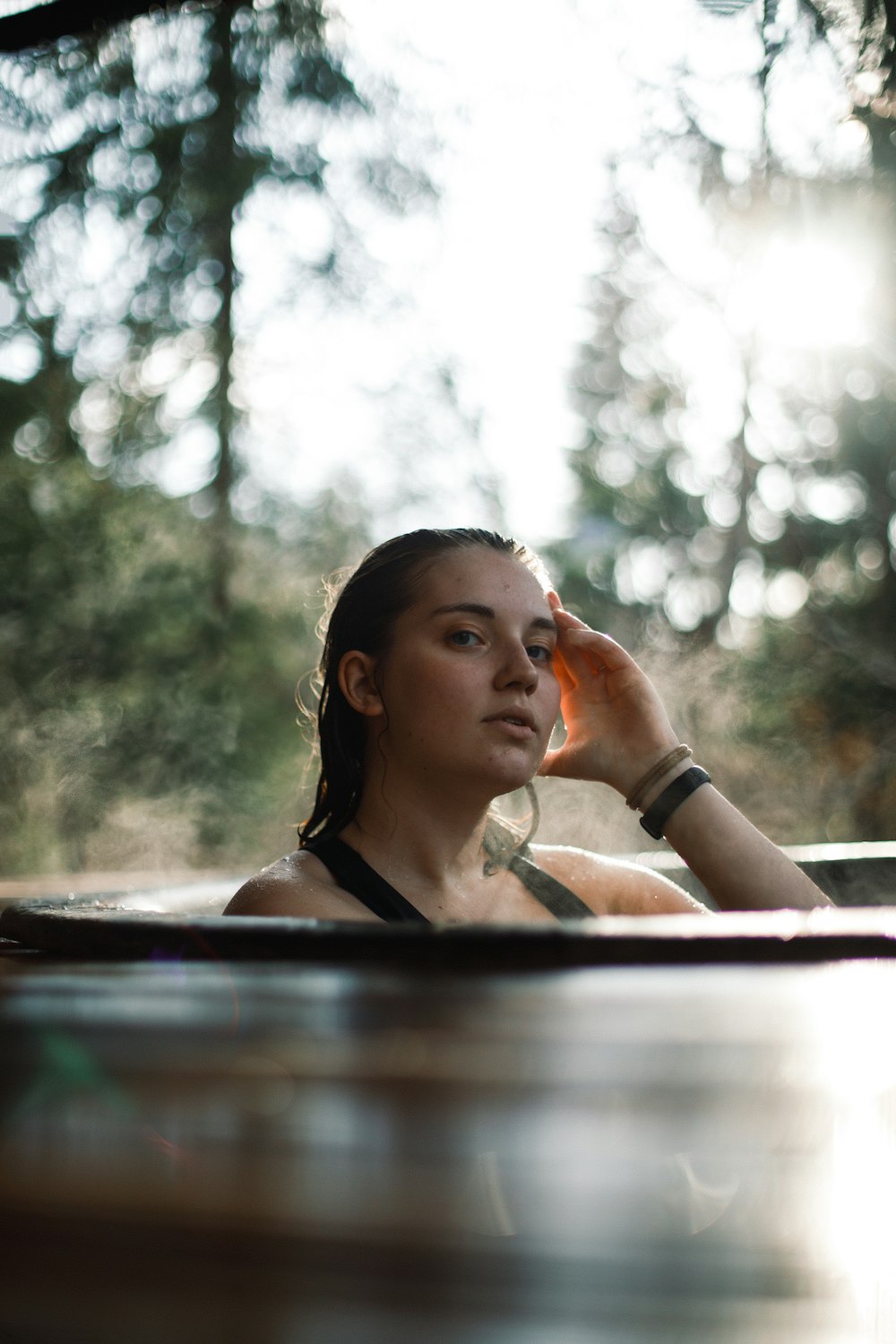 woman in black tank top sitting on brown wooden bench