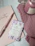 A cozy flat lay of pink pastel sneakers and a matching scented candle on a soft cream background.