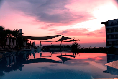 A serene poolside scene with rippling water reflecting soft blue hues at sunset.