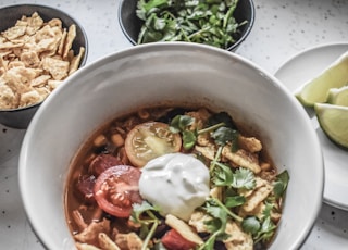 soup with sliced of vegetables in white ceramic bowl