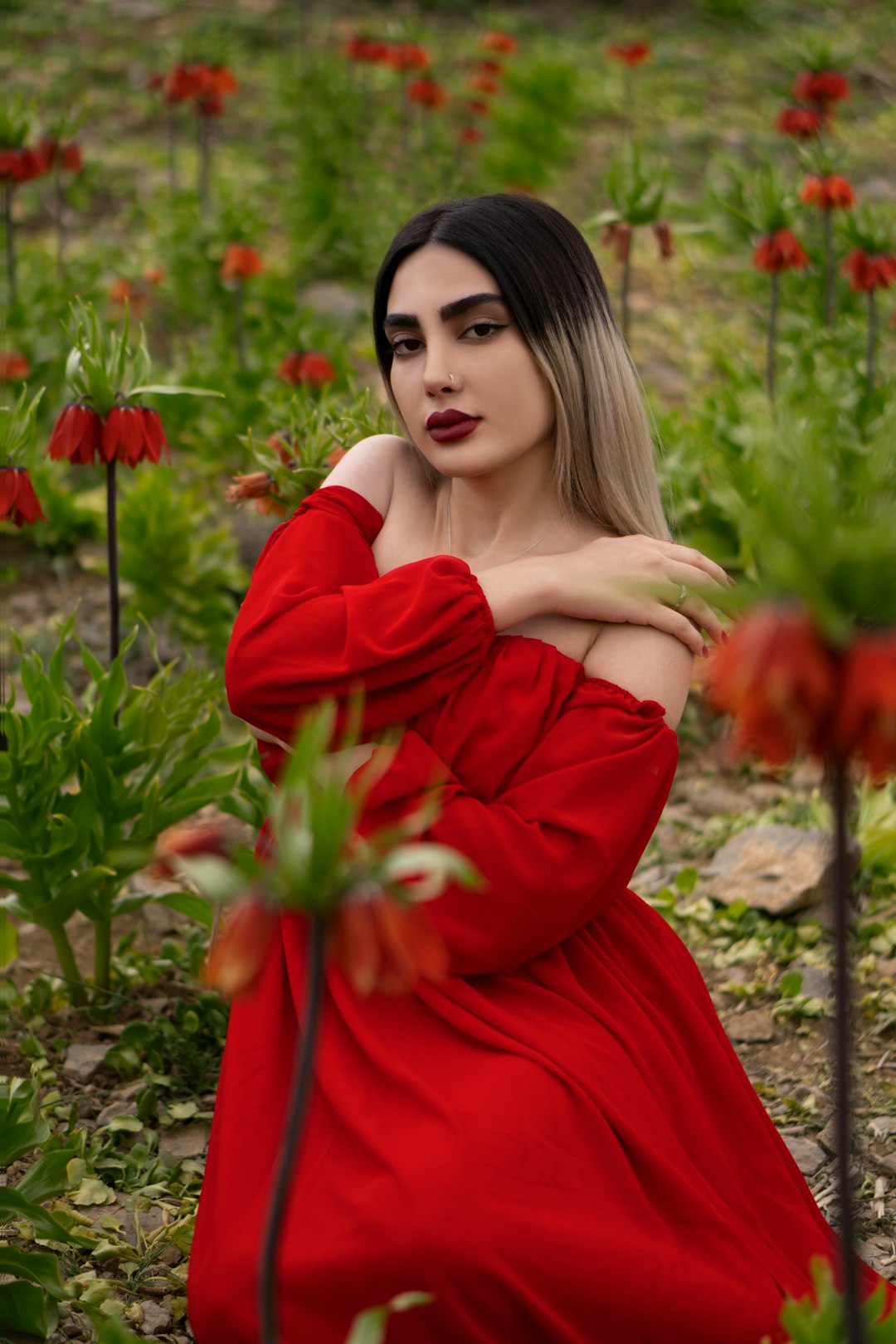 woman in red long sleeve dress holding red flowers