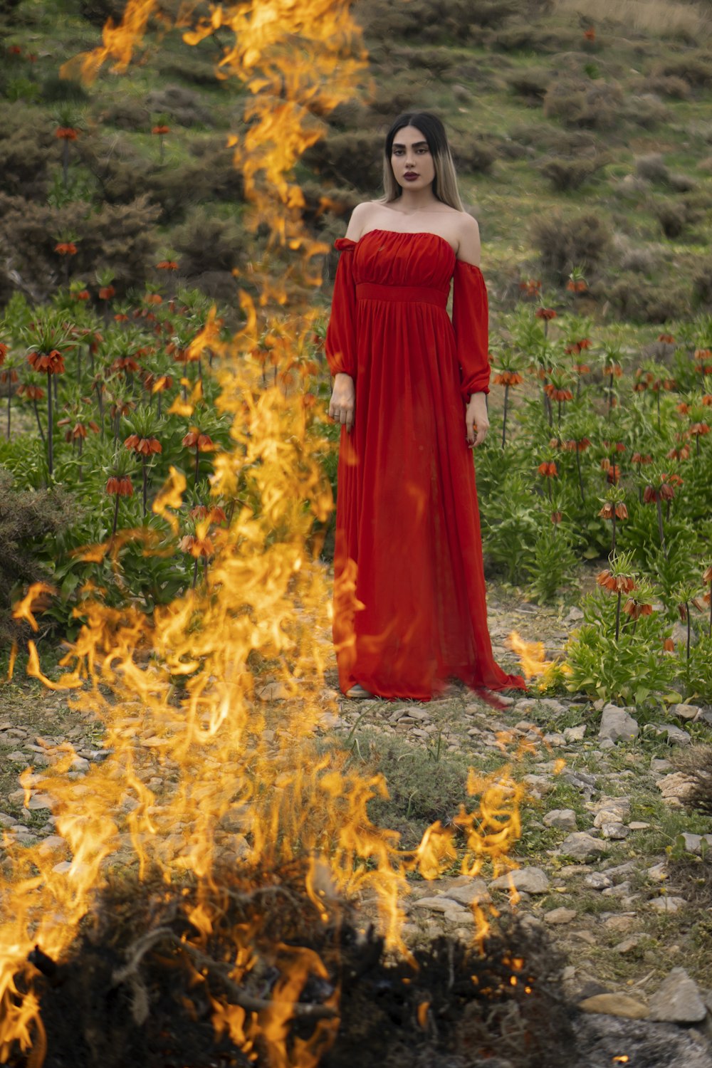 woman in red dress standing on yellow flower field during daytime