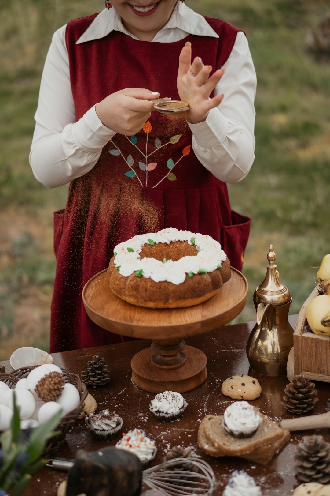 person in red and white long sleeve shirt holding brown wooden tray with cupcakes