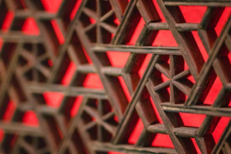 Close-up of colorful string art forming a geometric pattern on a wooden board