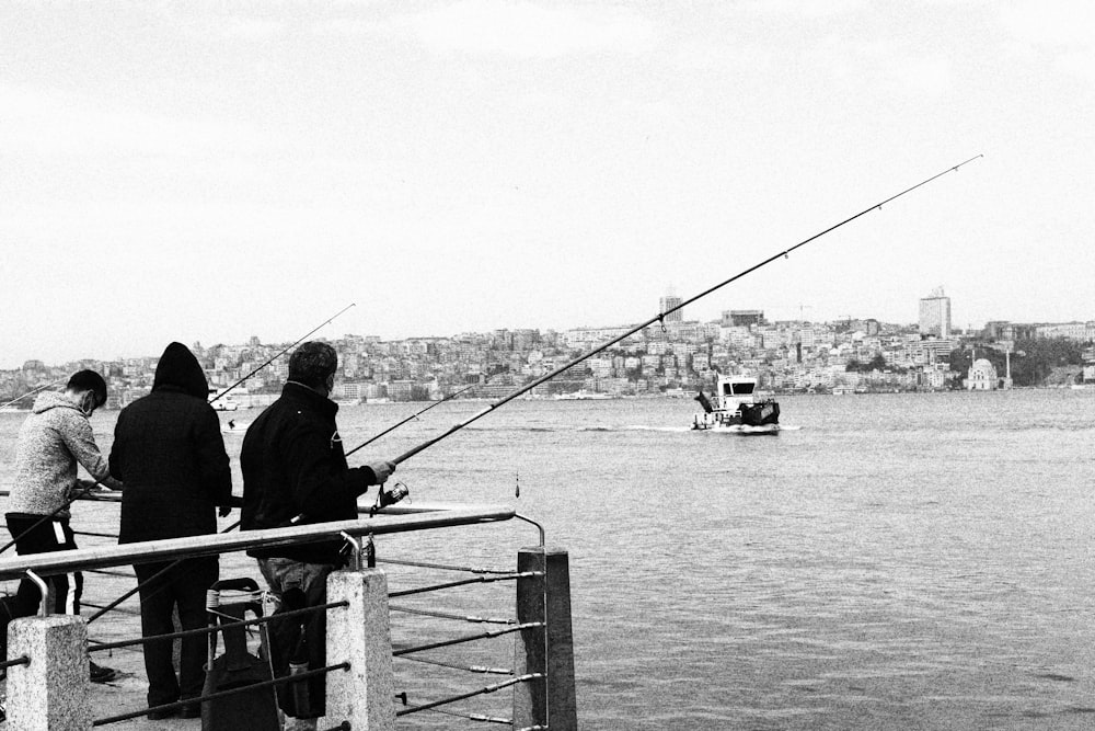 grayscale photo of people standing on boat