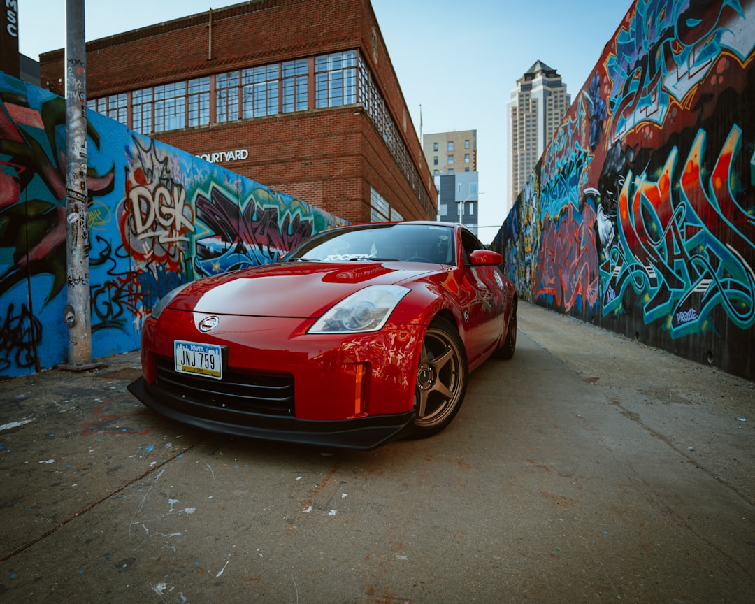 red ferrari car parked beside wall with graffiti