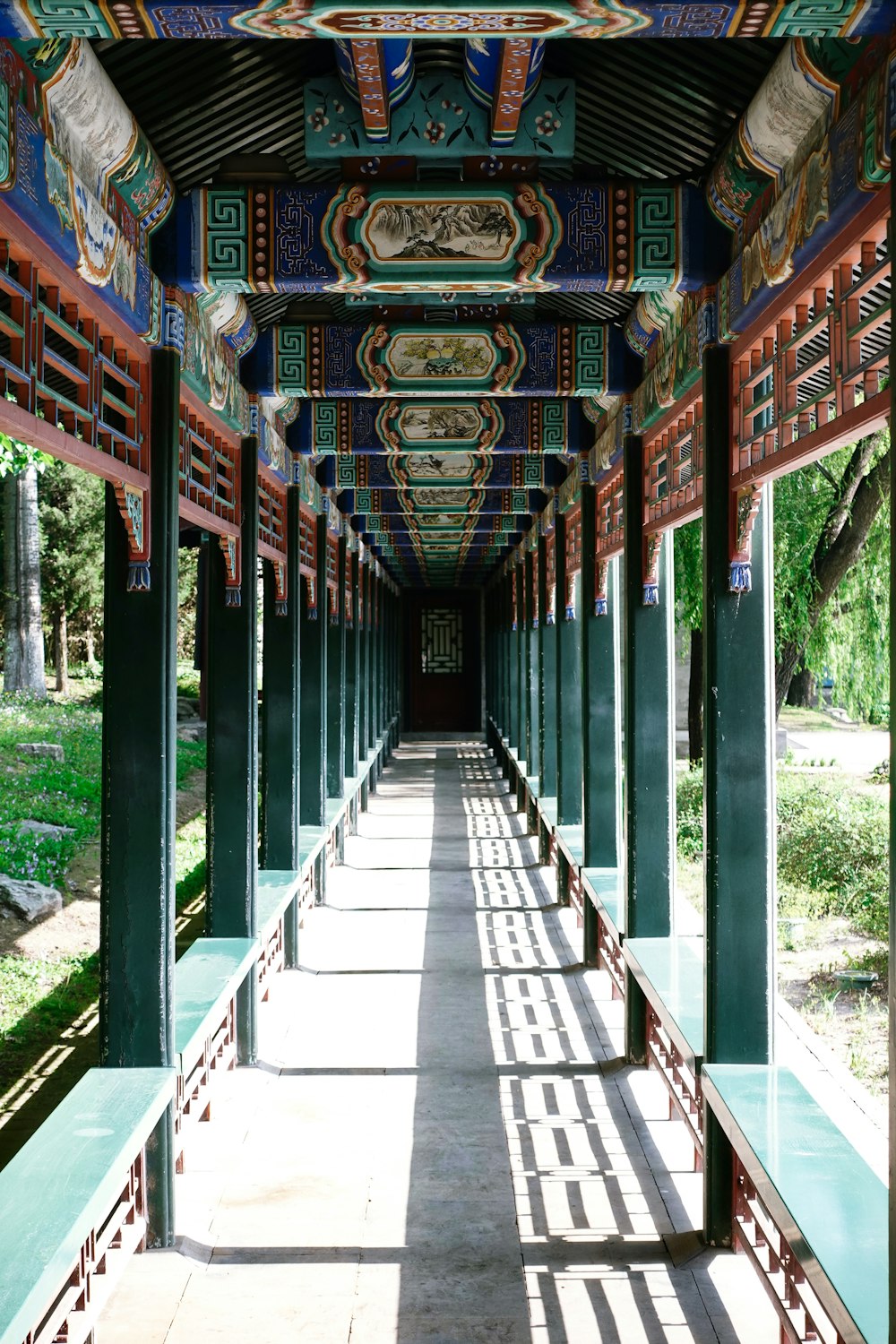 a long walkway lined with lots of green pillars
