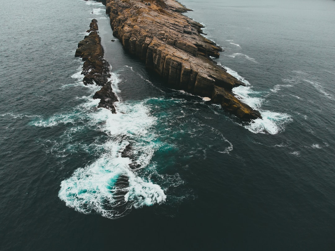 brown rock formation on body of water during daytime