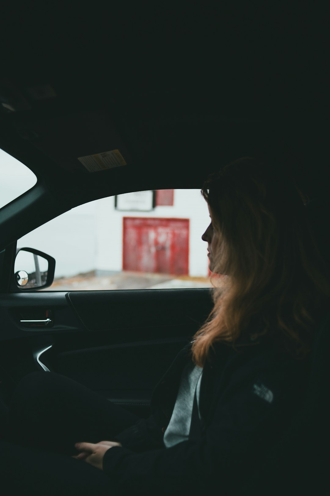 woman in black jacket driving car during daytime