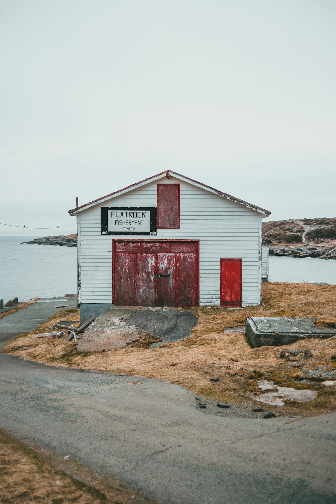 red and white wooden house near body of water during daytime