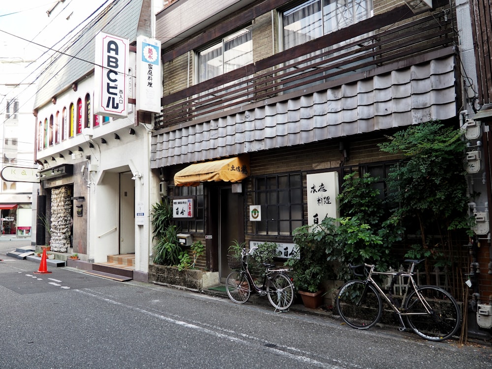 black bicycle parked beside white and brown concrete building during daytime