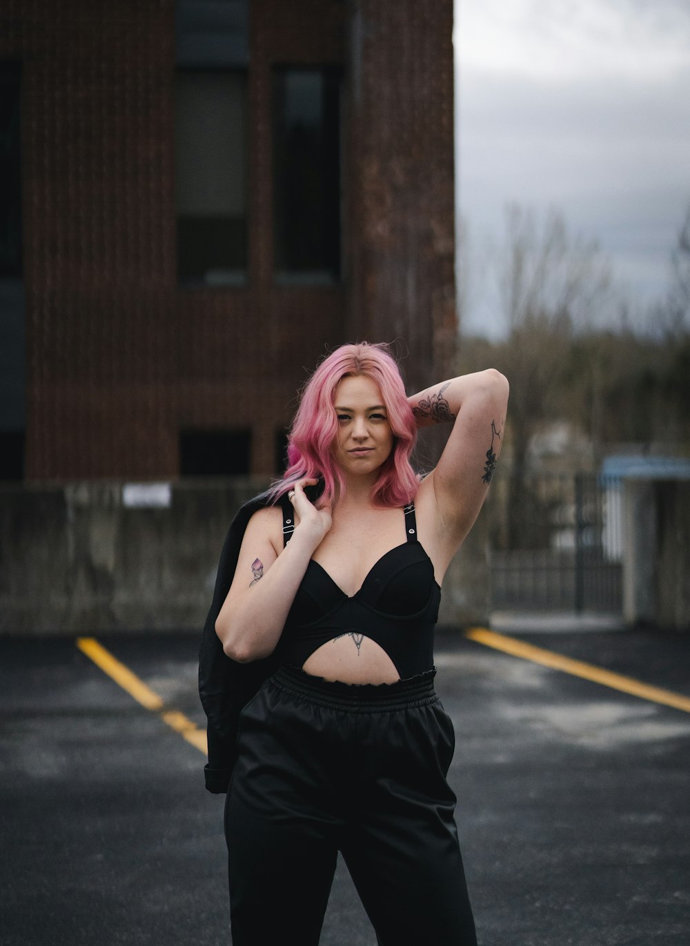 woman in black brassiere and black skirt holding her hair