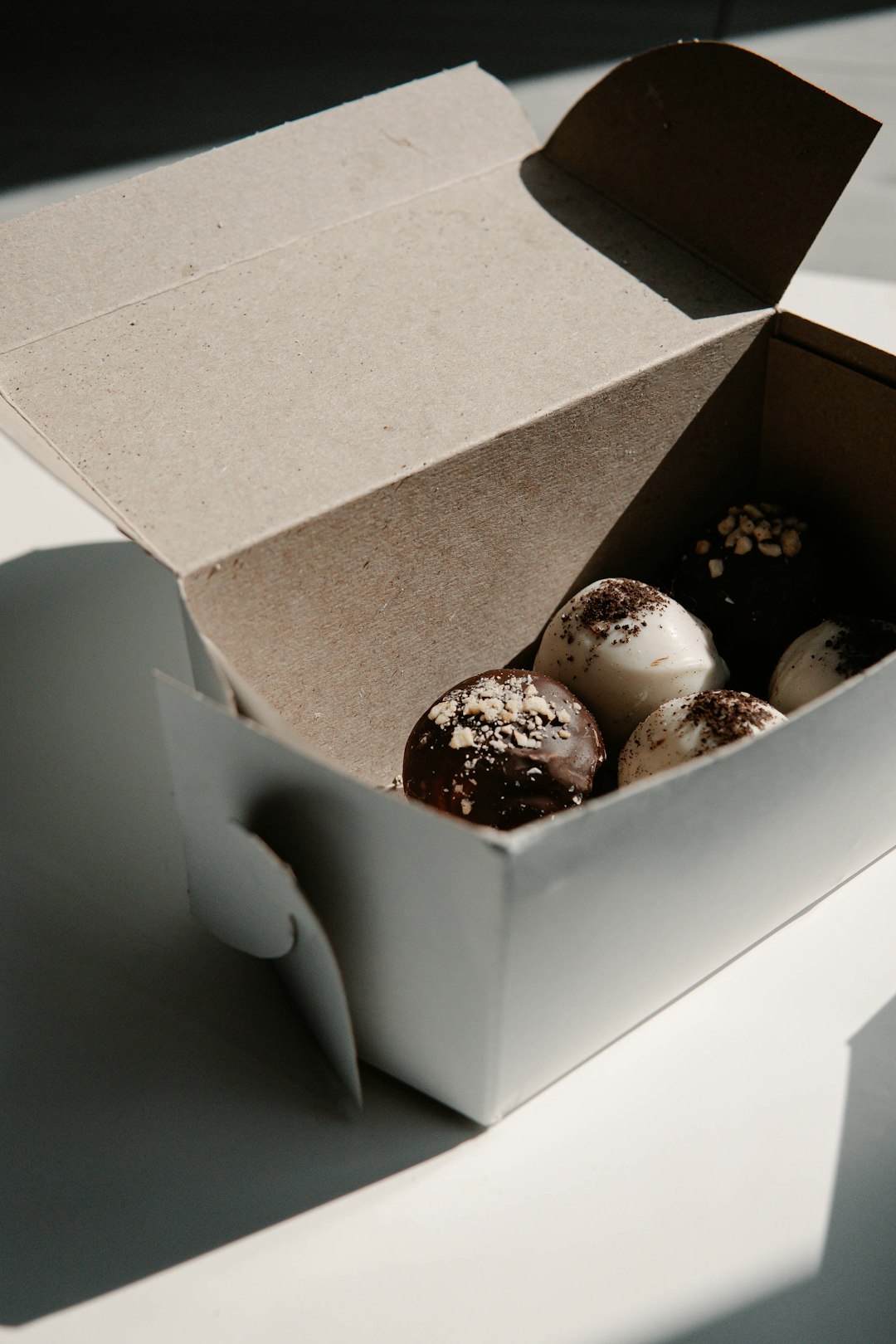 white and brown chocolate coated cookies in brown cardboard box