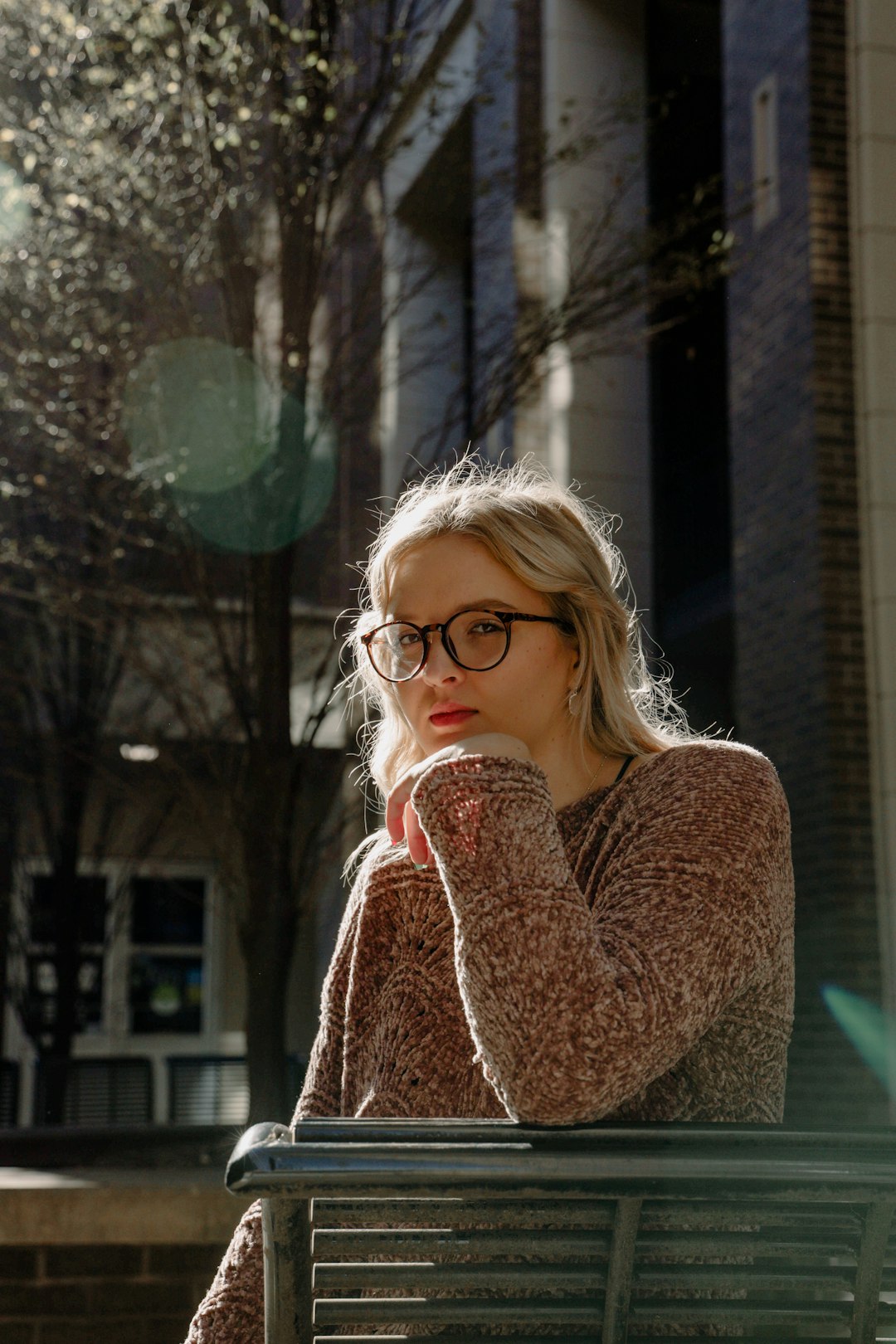 woman in brown sweater wearing eyeglasses