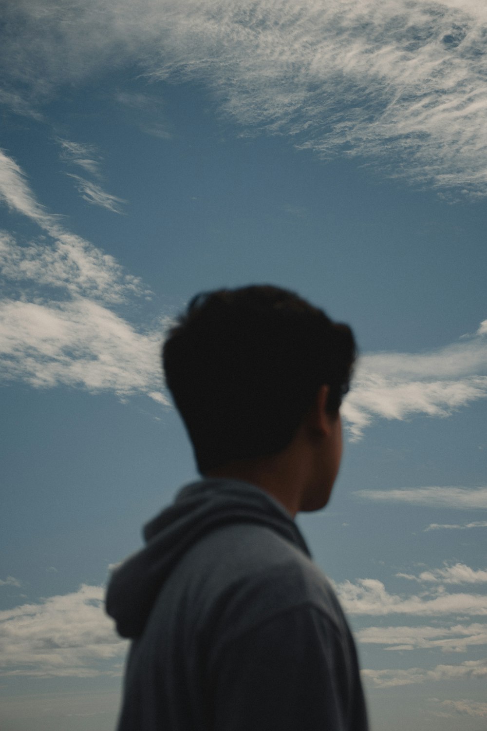man in gray hoodie under blue sky during daytime