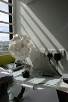 A modern office corner with a sleek lamp and various small office gadgets.