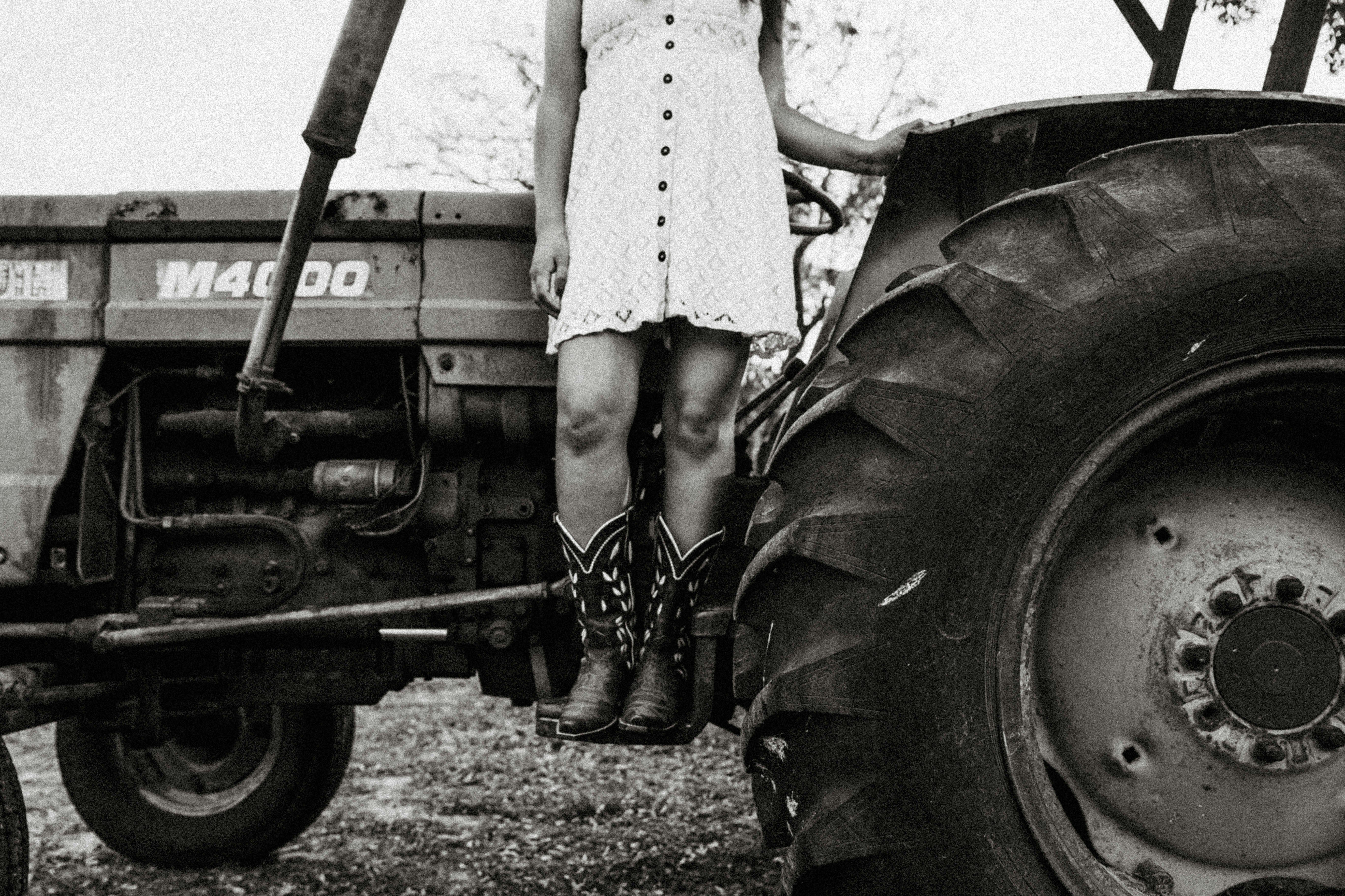 woman in white dress standing beside vintage car