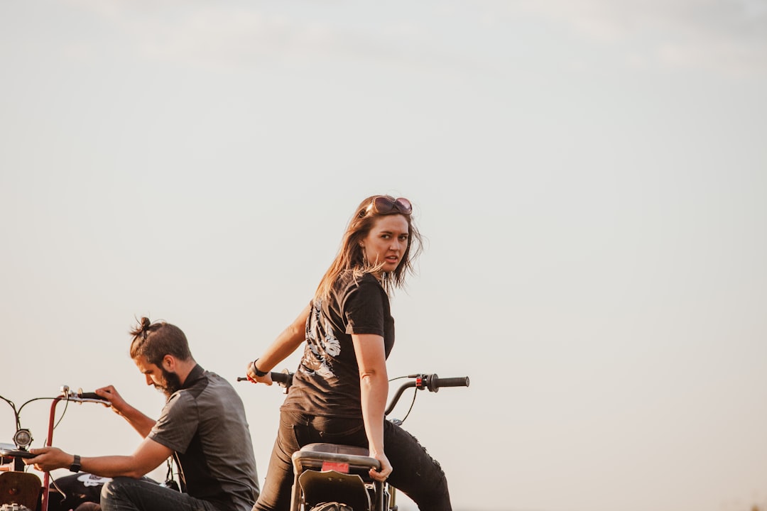 woman in black tank top sitting on motorcycle