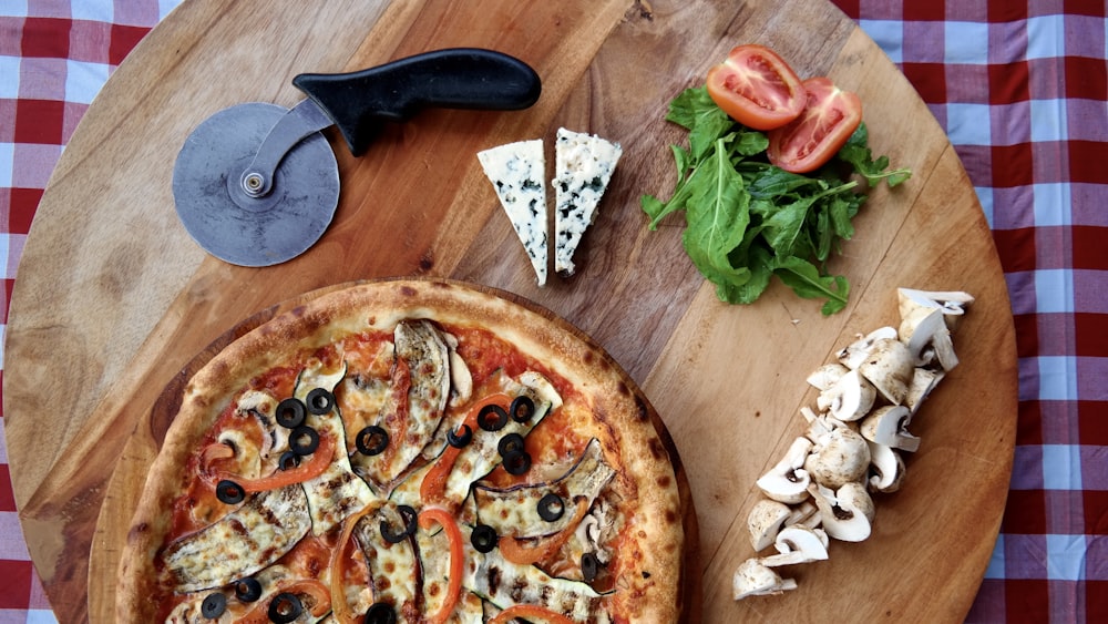 pizza with green leaves on brown wooden table