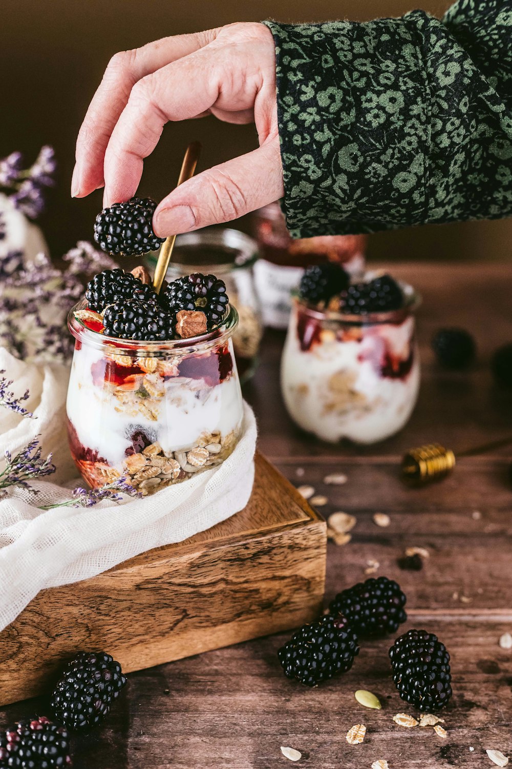 person holding ice cream cone with strawberry and blueberry