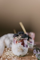 Artistic overhead shot of lavender milk poured into a bowl with granola and fresh berries, highlighting natural textures and colors.