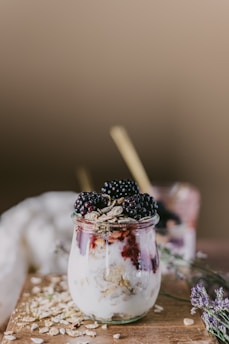 Artistic overhead shot of lavender milk poured into a bowl with granola and fresh berries, highlighting natural textures and colors.