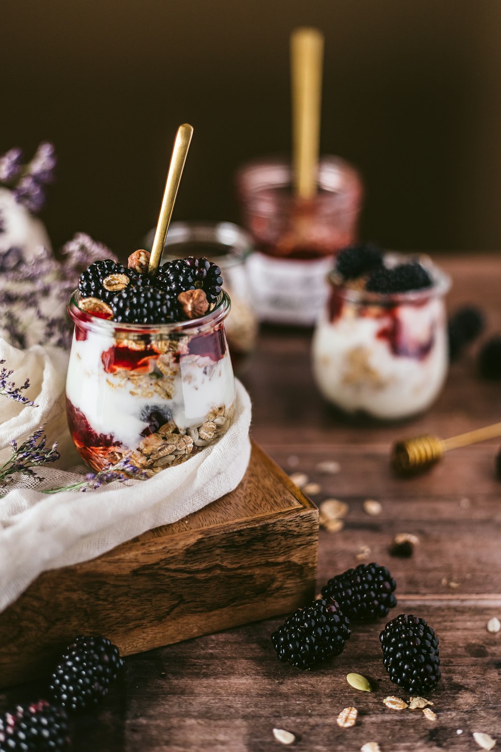 white ice cream with black berries on brown wooden table