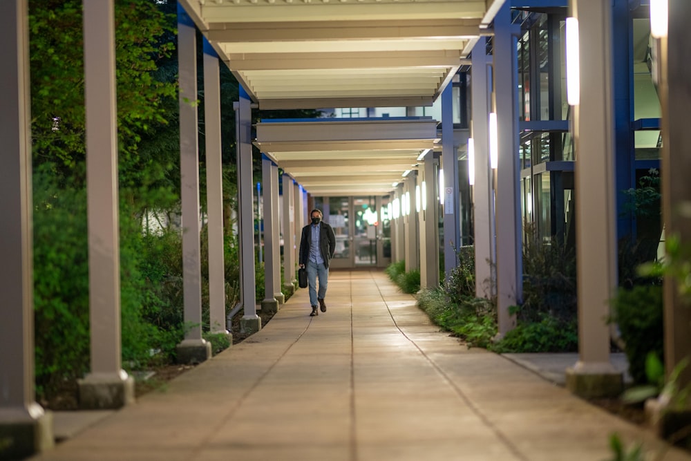 man in black jacket walking on hallway