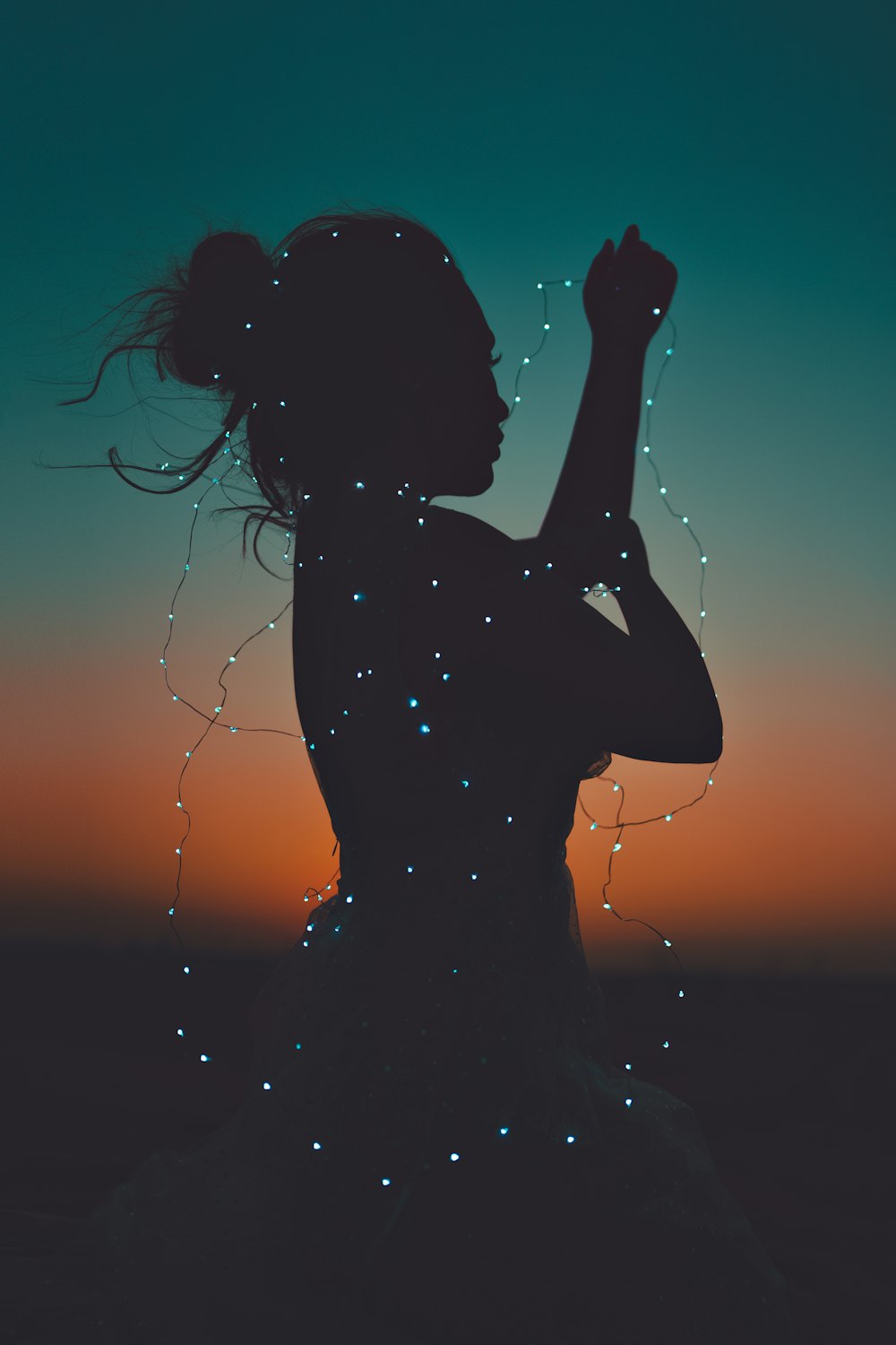 silhouette of woman holding her hair during sunset