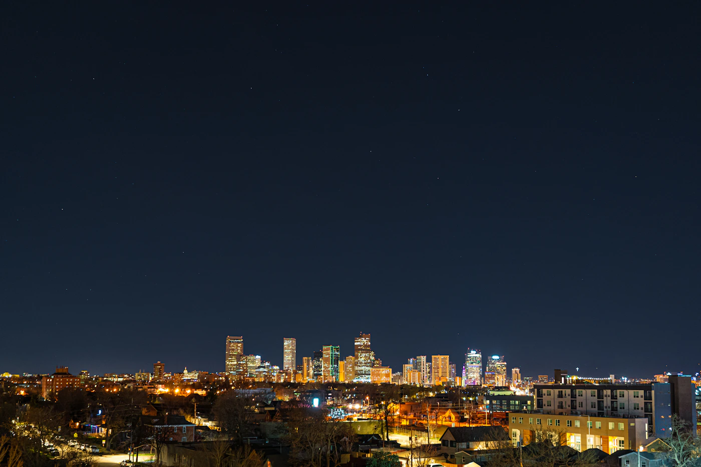 Denver Colorado skyline at sunset with Rocky Mountains in the background