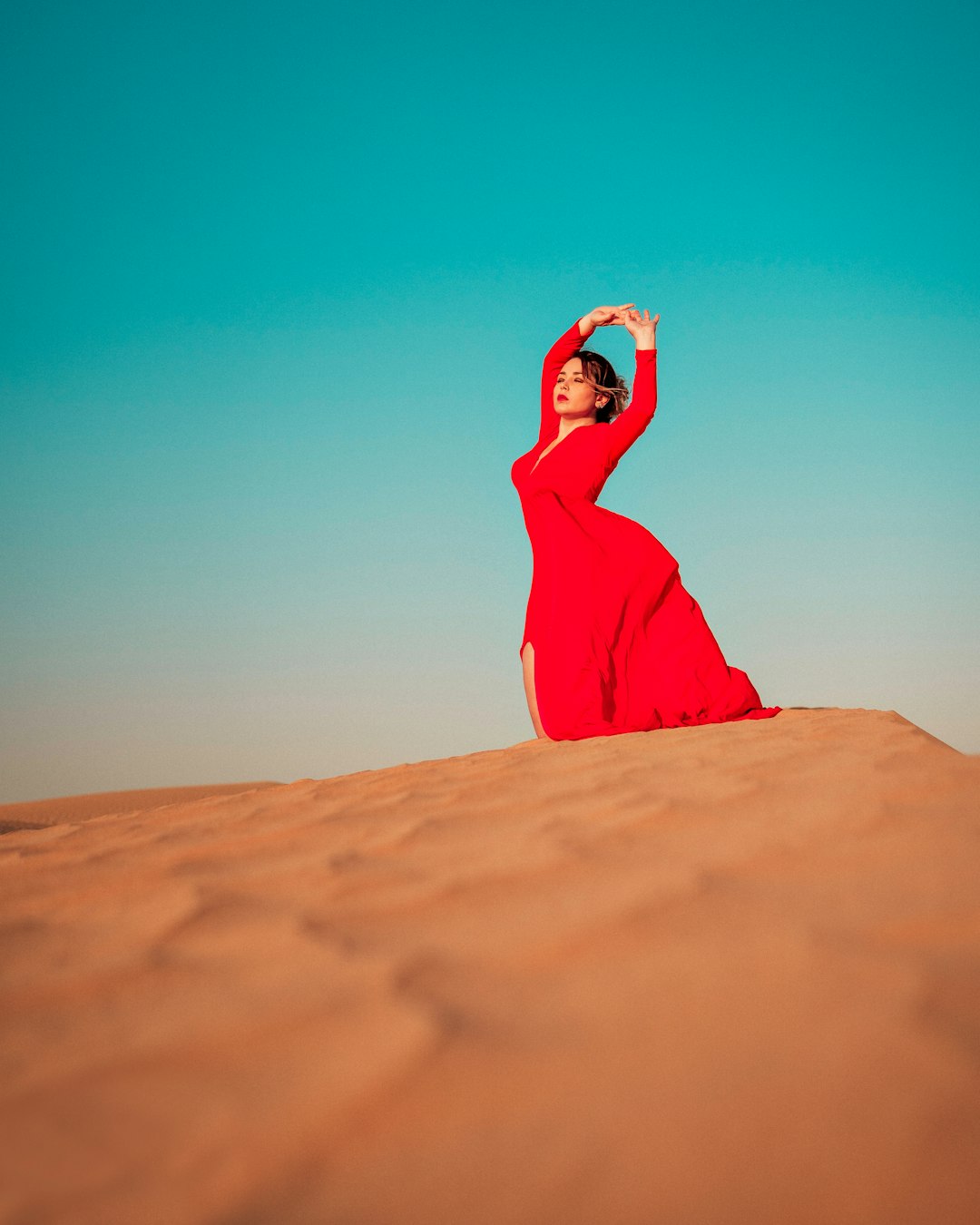 woman in red hijab covering her face with her hand