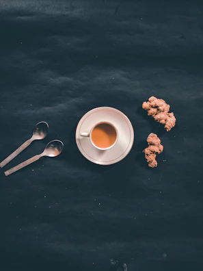A close-up of golden ginger tea served in a delicate porcelain cup.