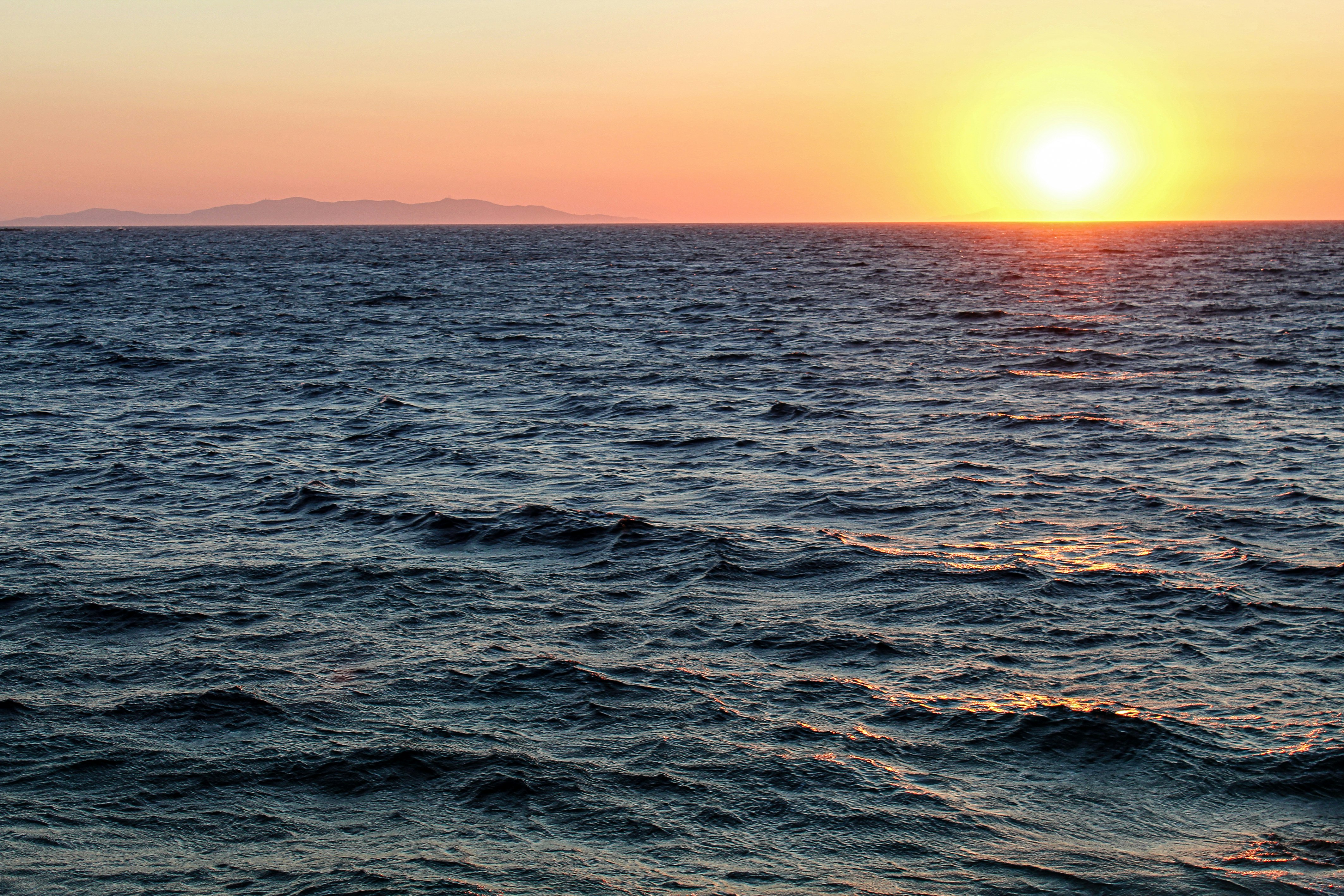 blue sea under orange sky during sunset