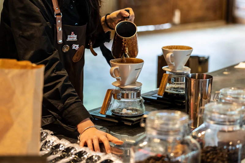 Person pouring coffee into a cup