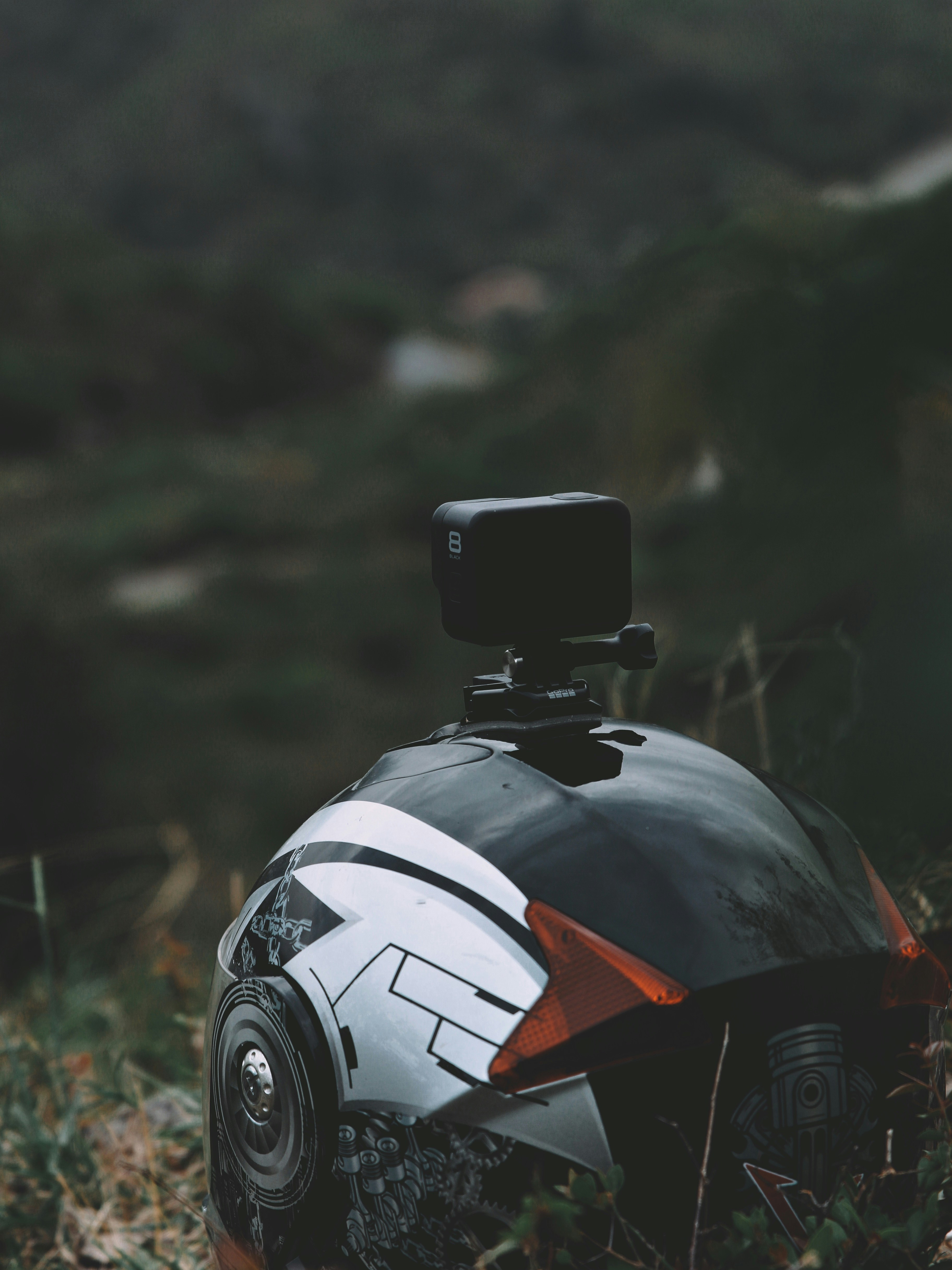 helm hitam dan oranye di atas rumput hijau di siang hari