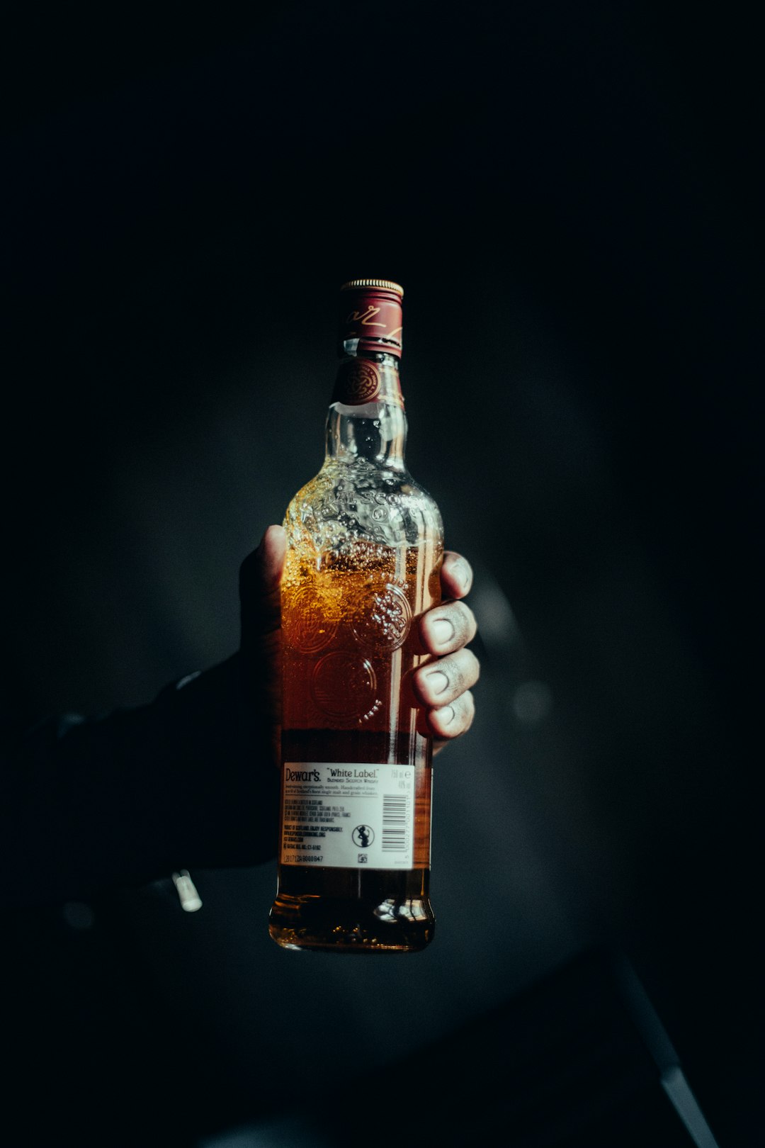 person holding white labeled bottle