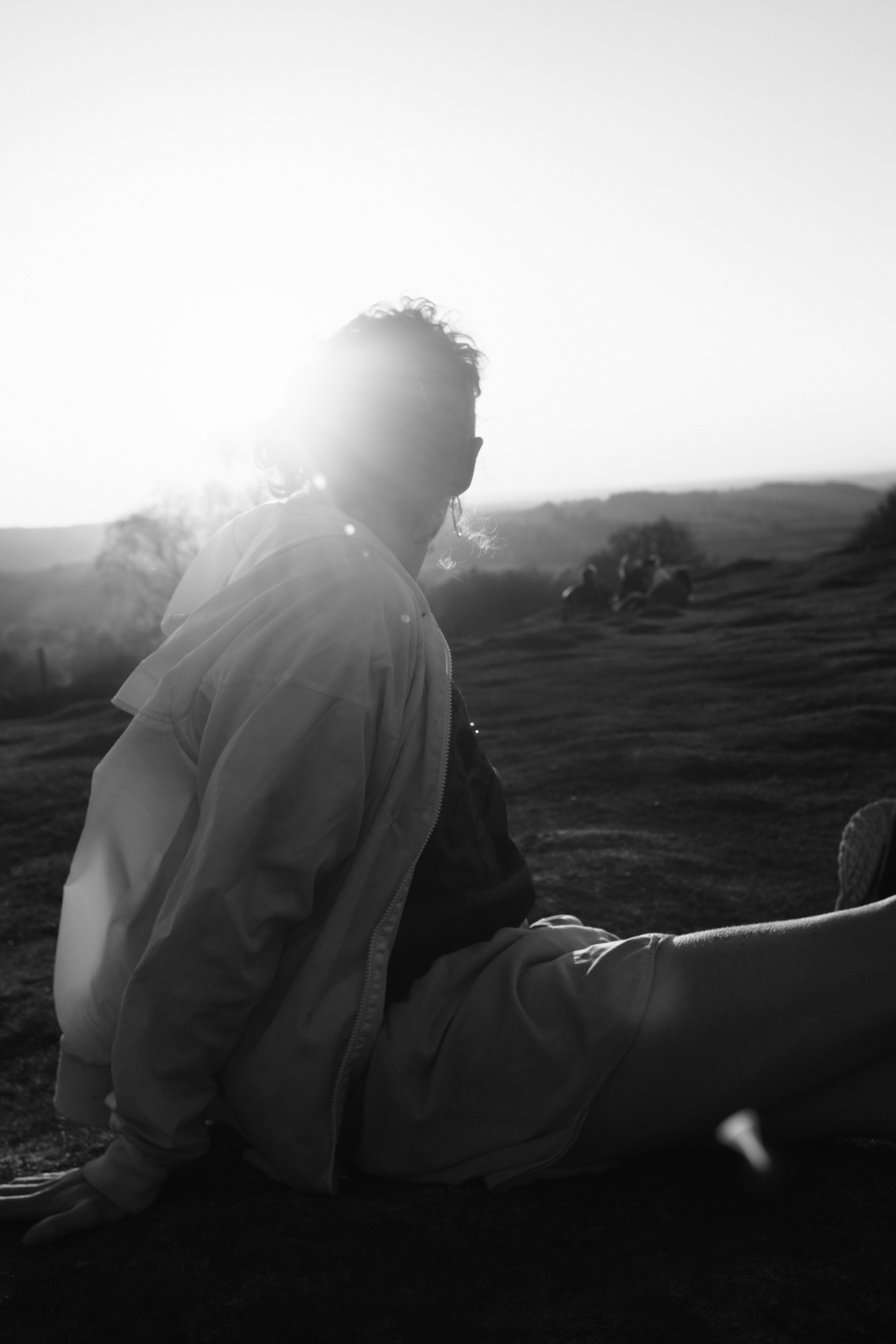 man in black jacket sitting on rock