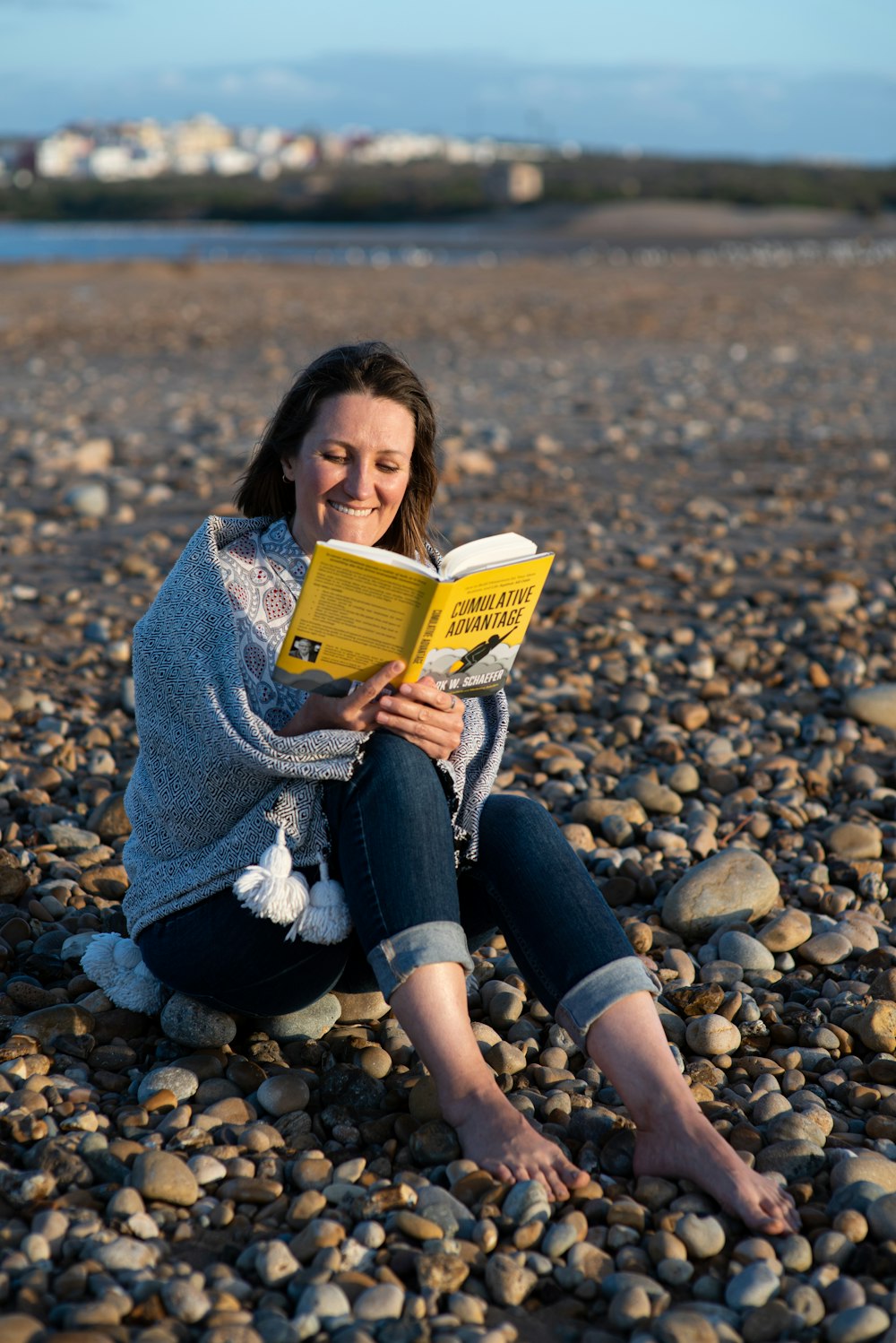 woman in gray sweater and black pants sitting on gray rock