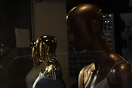 A cinematic lookbook scene featuring models in matte gold and beige tones with smooth transitions.