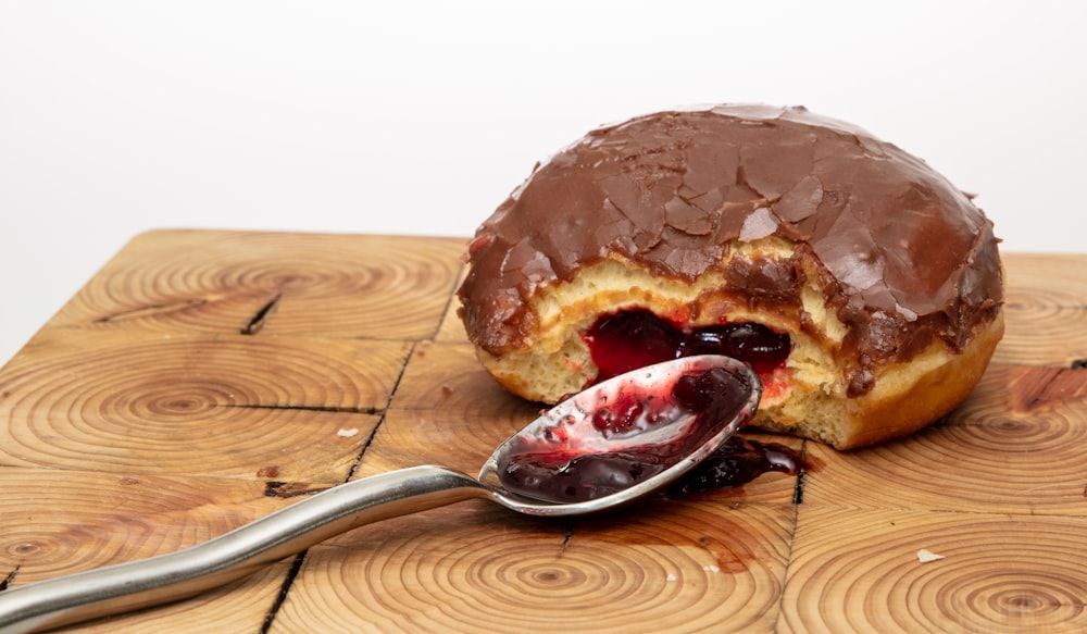 a doughnut with chocolate frosting and a spoon