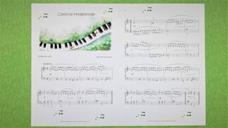 A sheet of classical music titled 'Classical Hodgepodge' is displayed, featuring a whimsical illustration of a piano keyboard flowing through a grassy landscape. The sheet contains musical notes and compositions on a white background, with additional decorative musical notes around the edges. The pages are set against a light green textured background.
