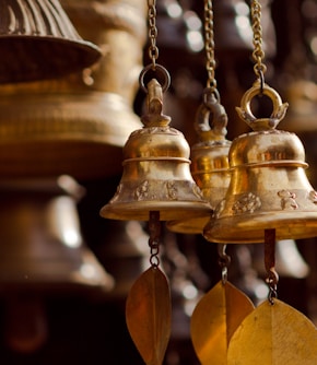 gold bell hanging on brown wooden wall