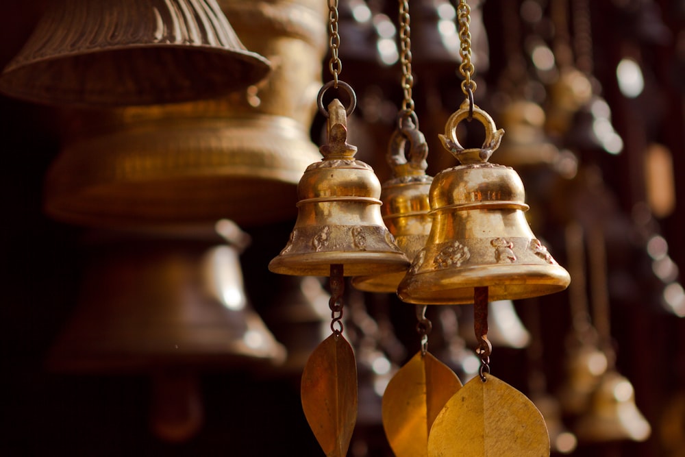 gold bell hanging on brown wooden wall