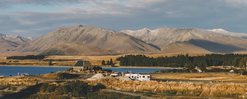 white and brown house near green trees and mountains during daytime