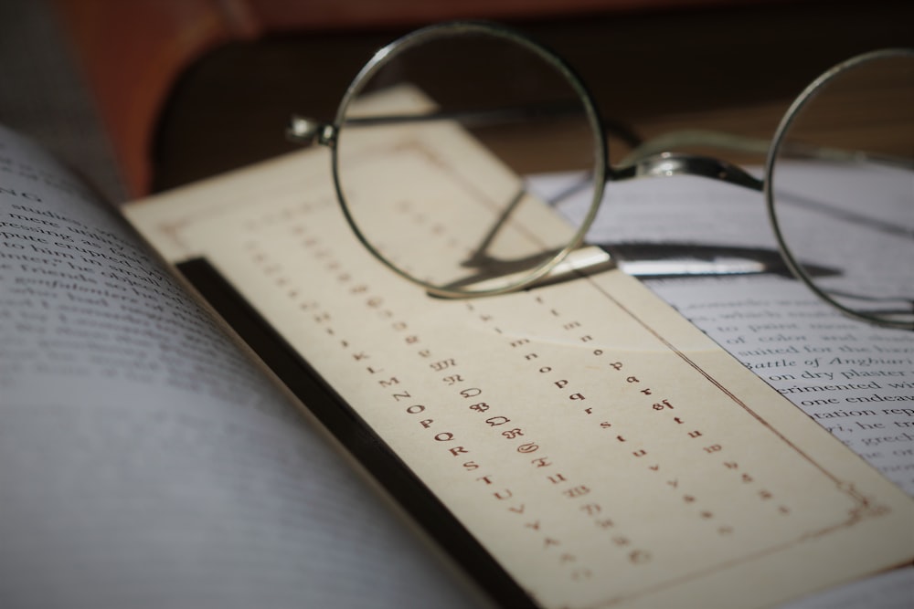 silver framed eyeglasses on white printer paper