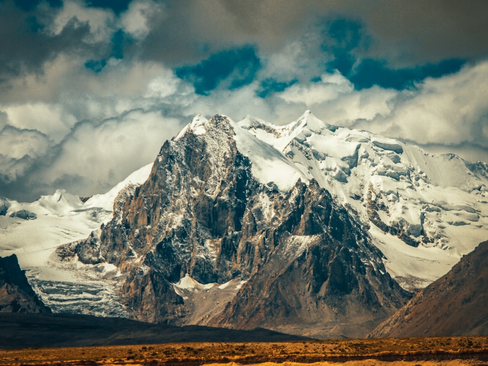 snow covered mountain under cloudy sky during daytime