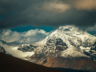 snow covered mountain under cloudy sky during daytime