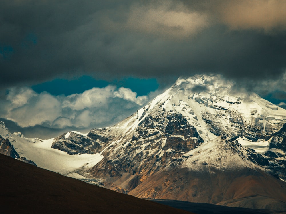 snow covered mountain under cloudy sky during daytime